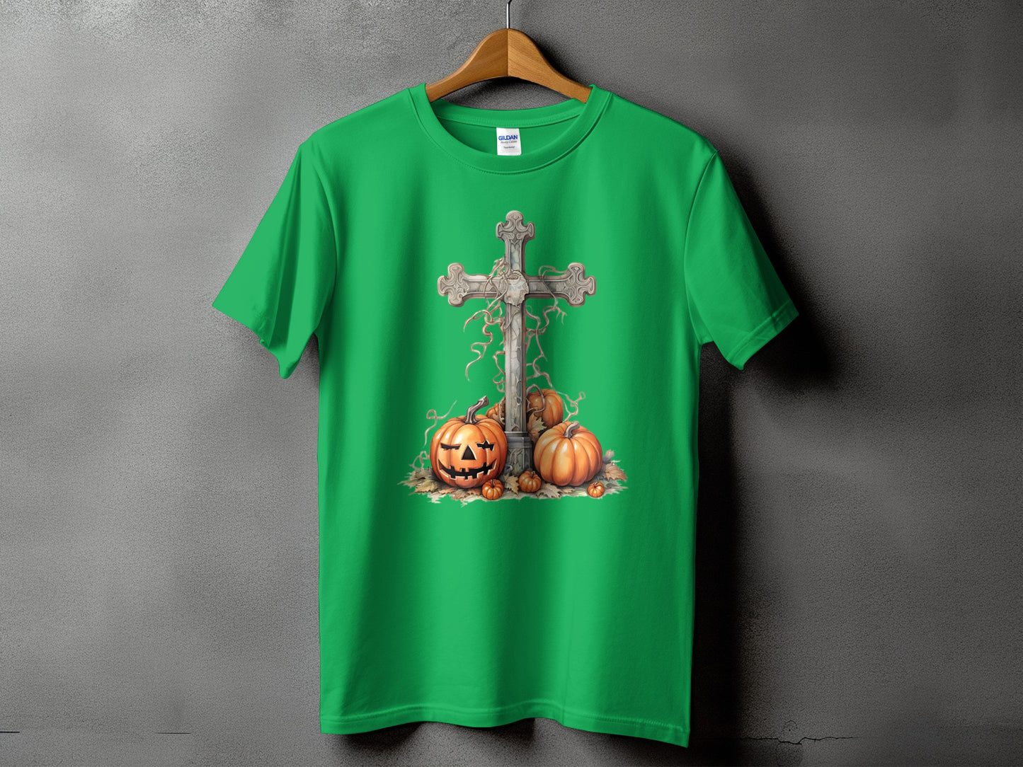 Green t-shirt with a stone cross and pumpkins graphic.