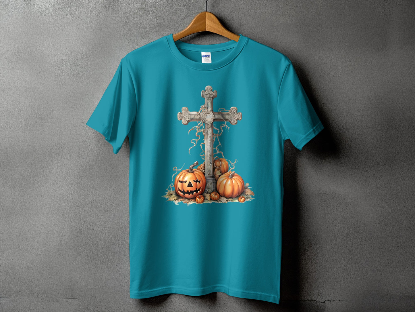 Turquoise t-shirt with a stone cross and pumpkins graphic.