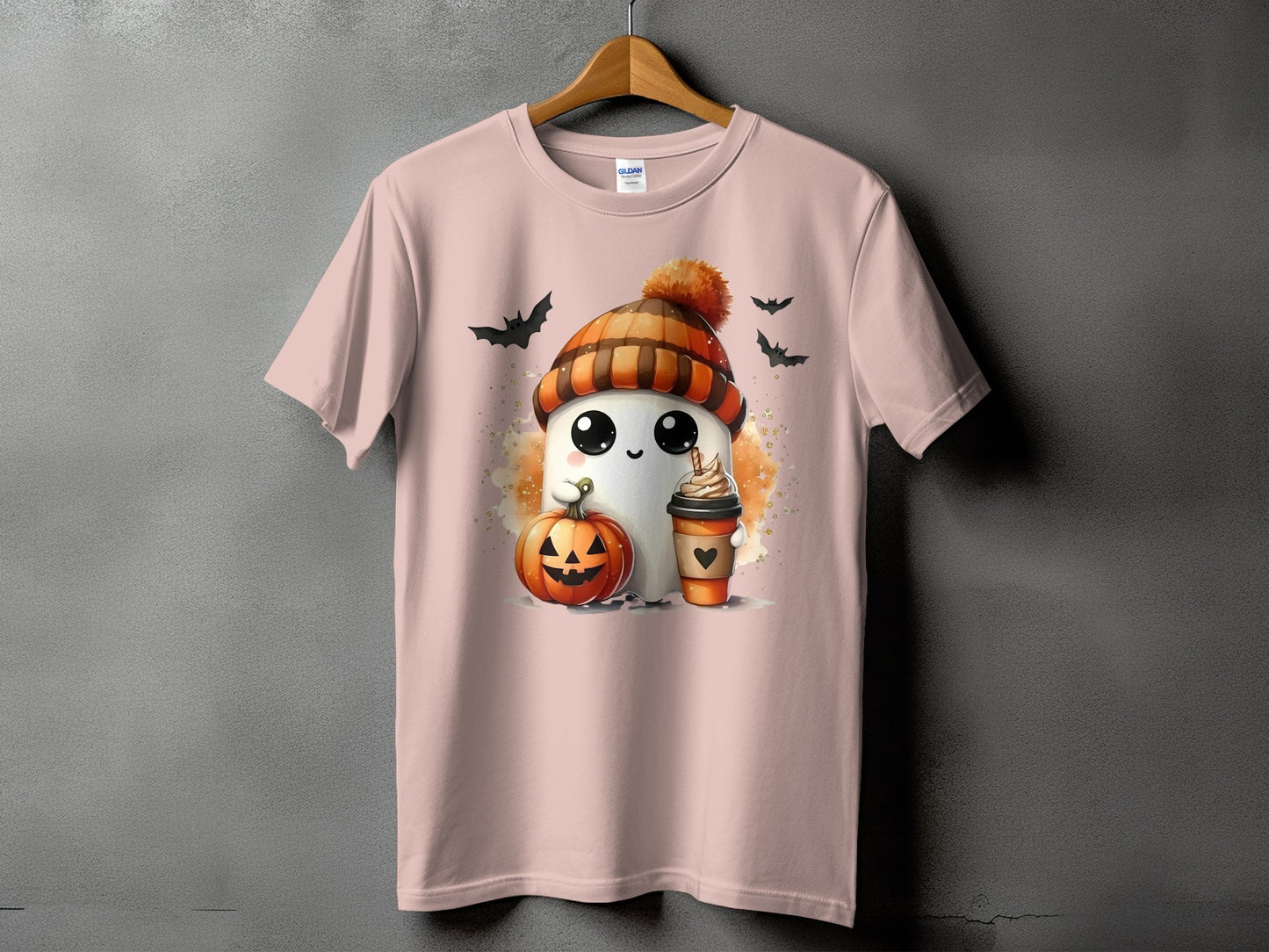 Ghost with pumpkin and coffee on a light pink t-shirt, surrounded by bats.