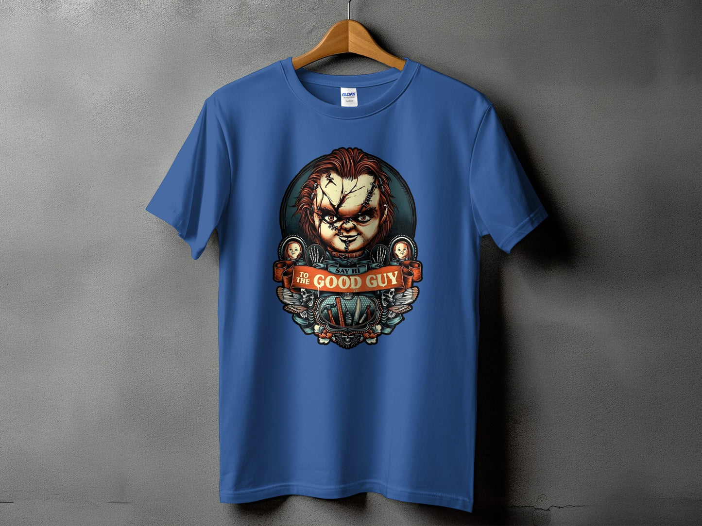 Blue t-shirt with Chucky design and the text "TO THE GOOD GUY SAY HI".