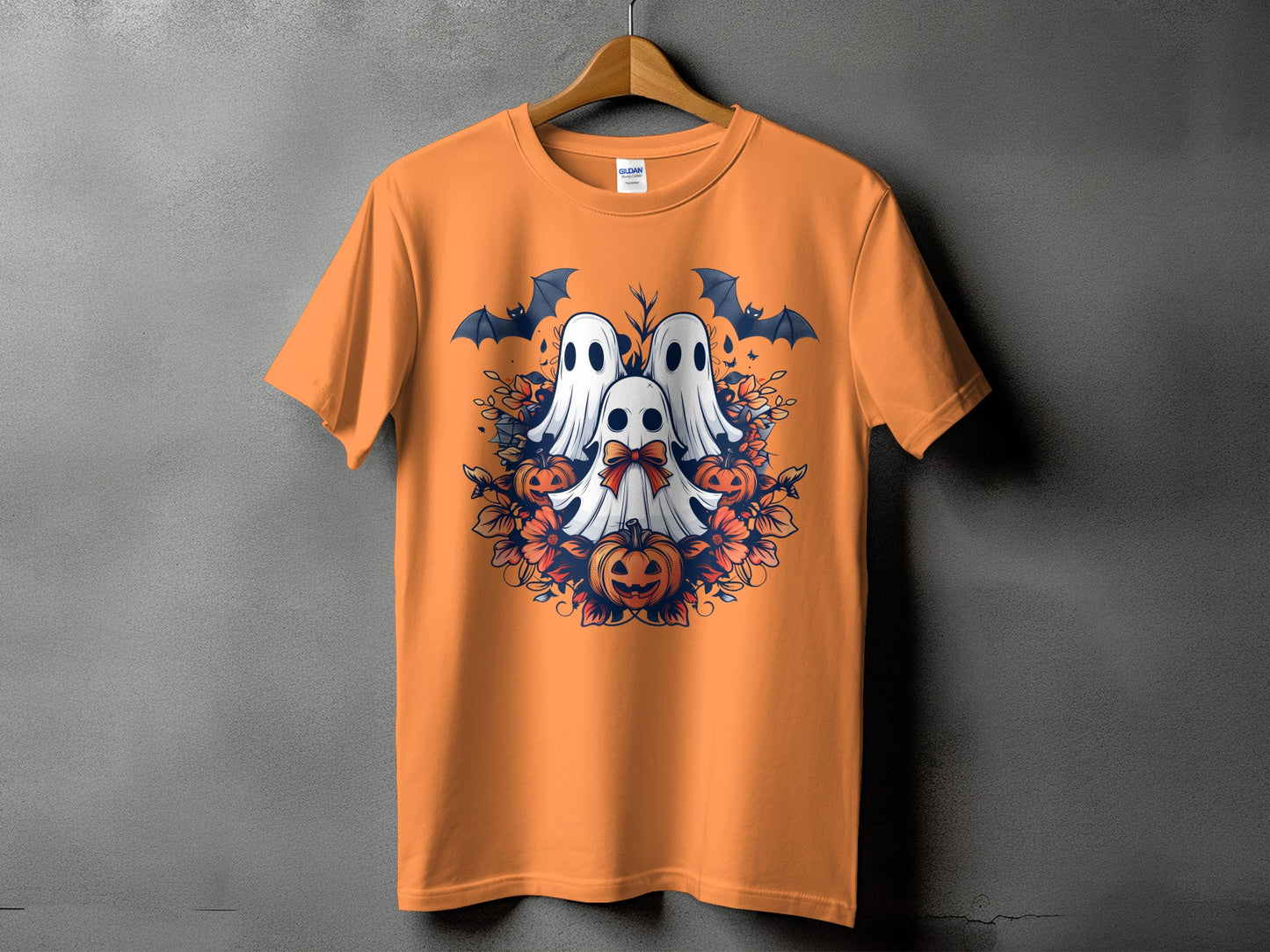 Orange t-shirt with a circular Halloween design featuring three ghosts, bats, and pumpkins.