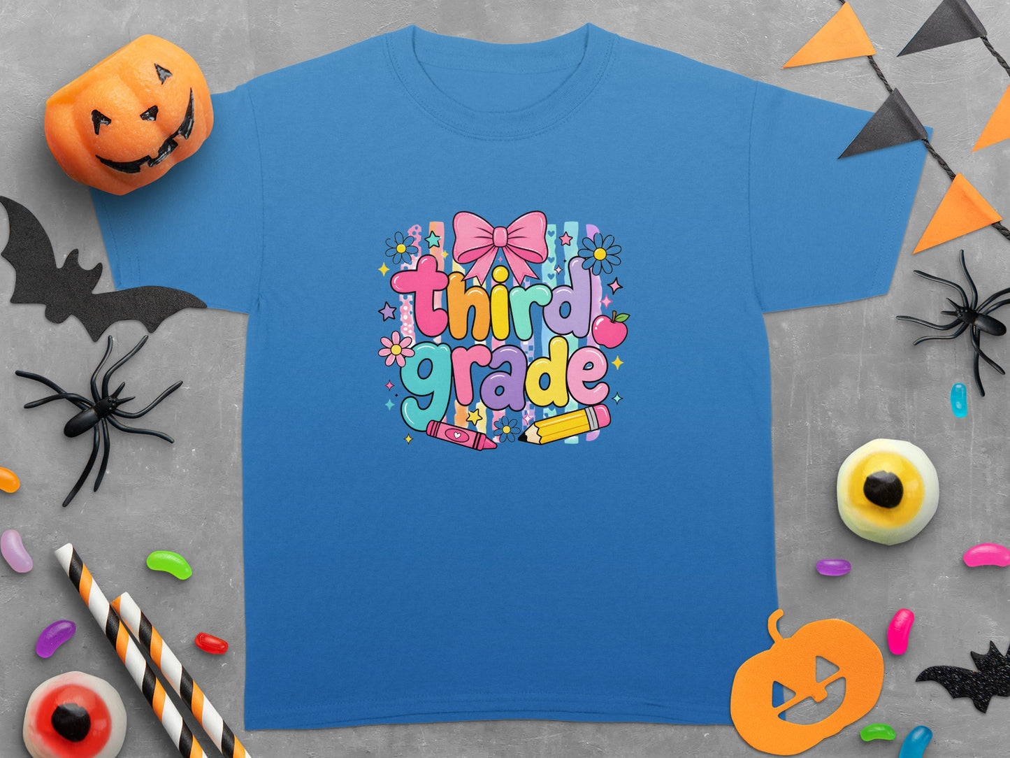Blue t-shirt with "third grade" text, bow, flowers, crayon, and pencil graphics.