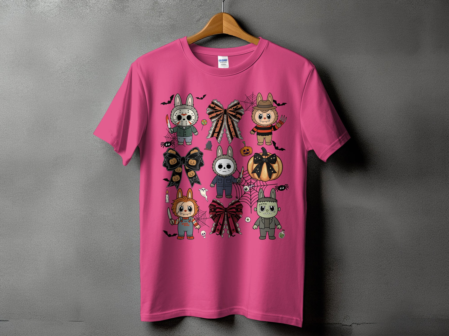 Pink t-shirt with cartoon Halloween characters and bows, including Chucky, Michael Myers, Frankenstein, and Freddy Krueger.