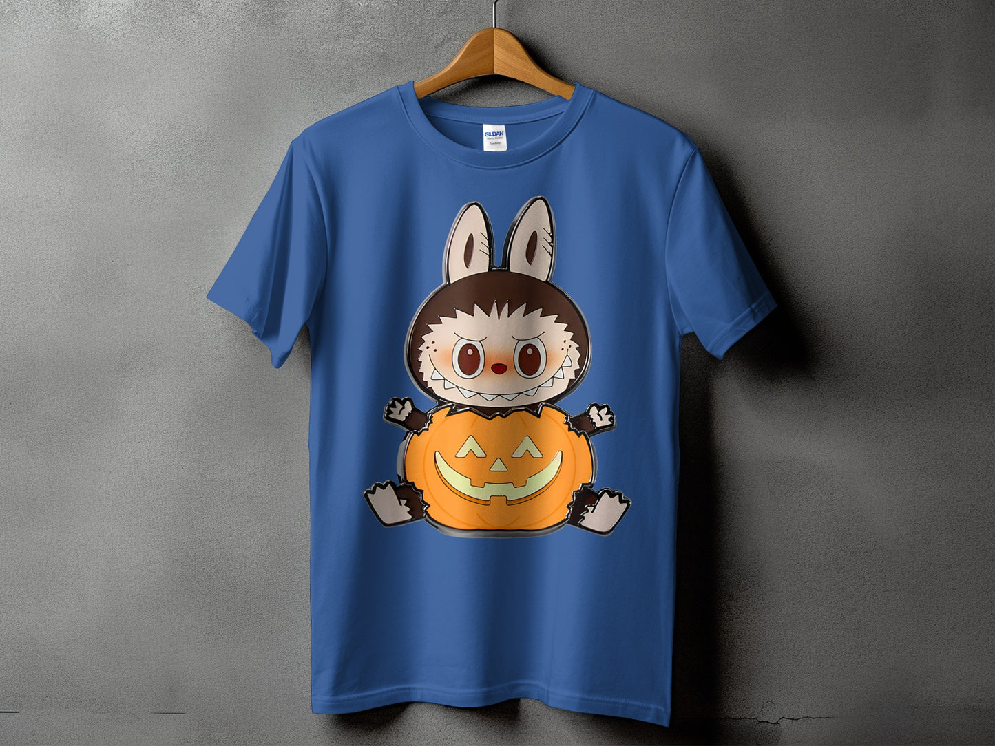 Blue t-shirt with a cartoon creature sitting inside a jack-o'-lantern.