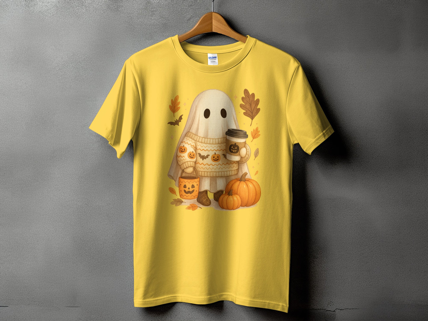 Yellow t-shirt with a ghost in a sweater holding coffee and pumpkins.