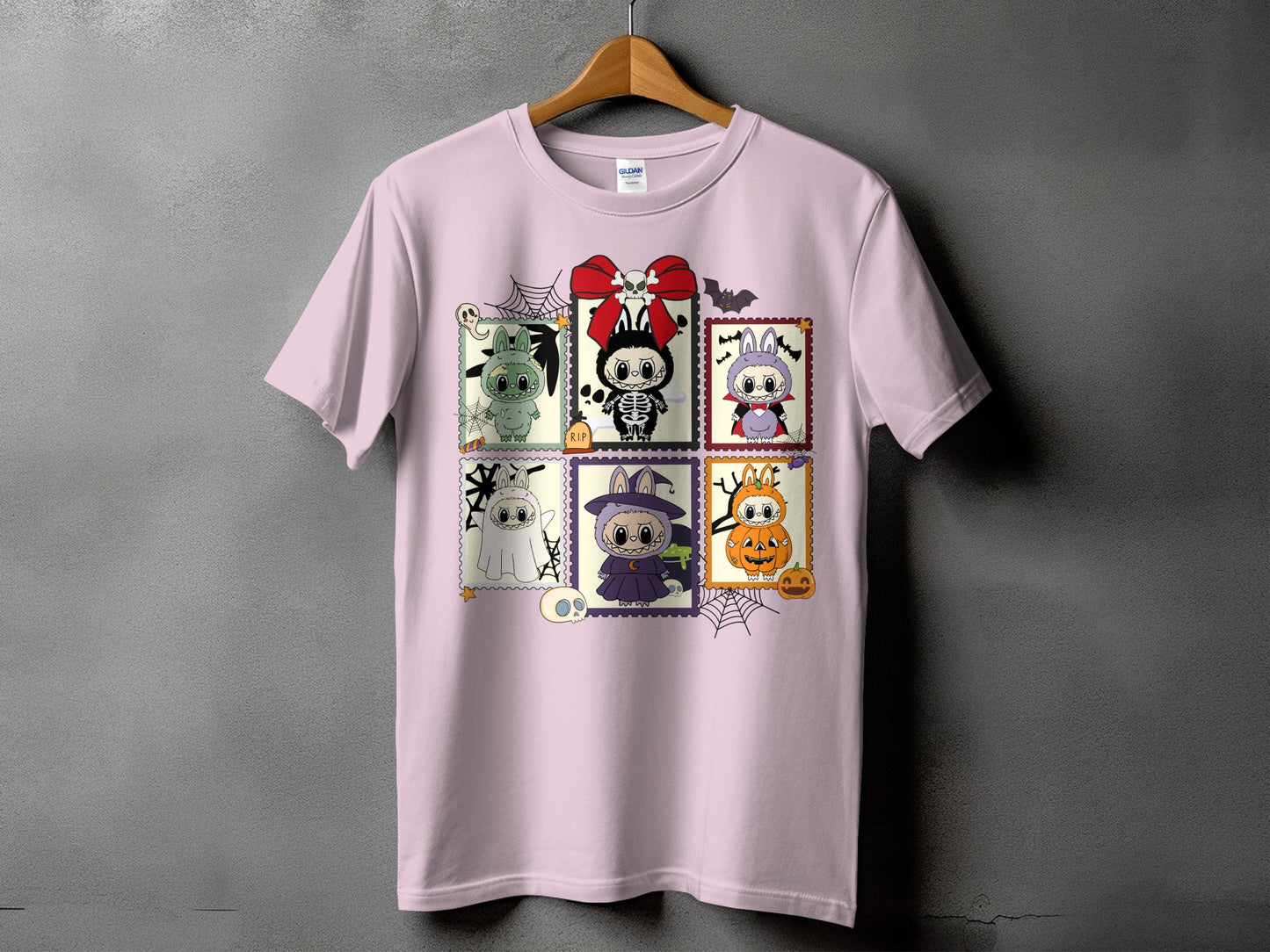 Pink t-shirt featuring six Halloween-themed cartoon stamp designs.