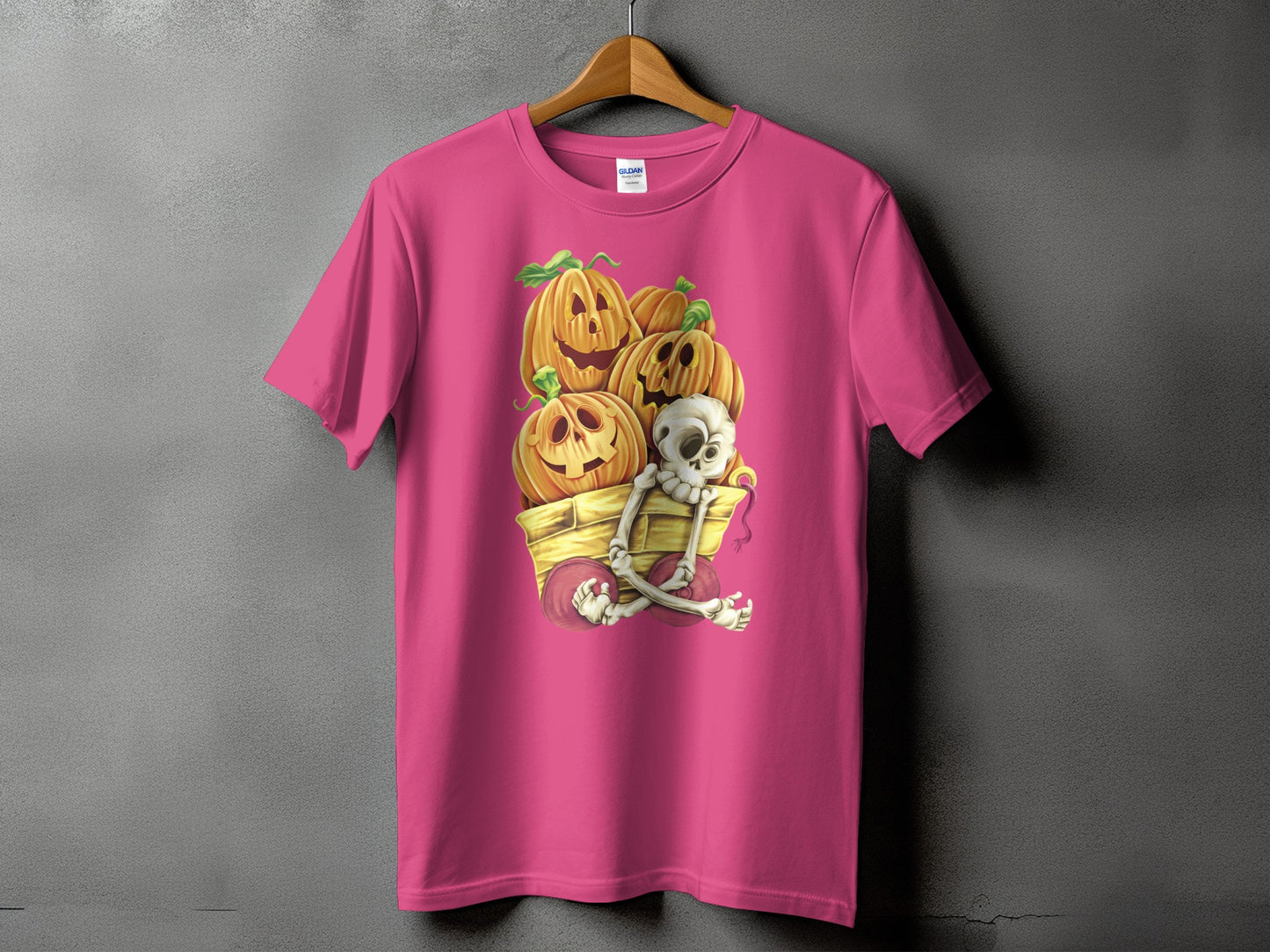 Pink t-shirt with Halloween cart graphic featuring pumpkins and a skeleton.