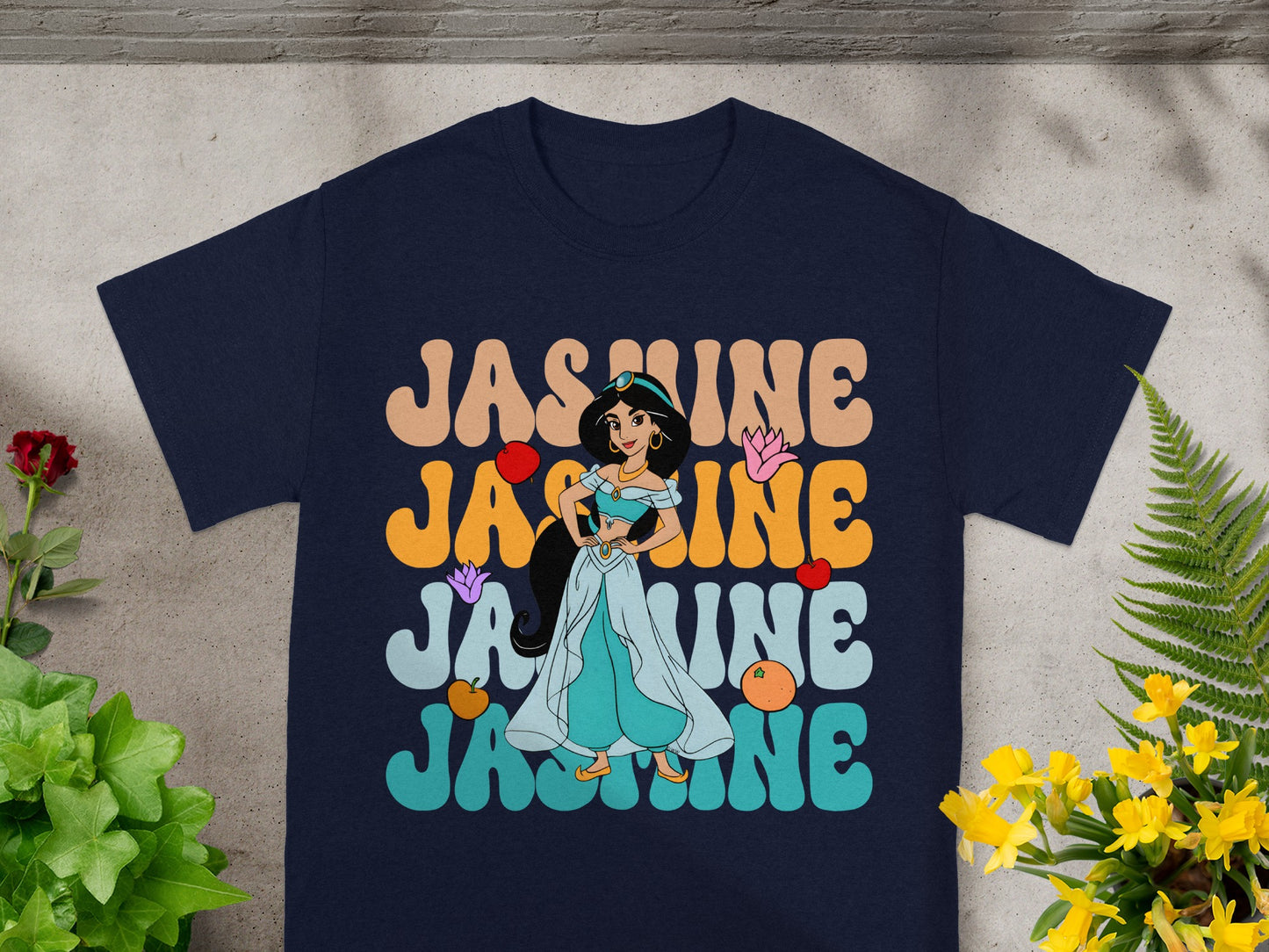Navy t-shirt with "Jasmine" in colorful, retro font and character illustration.
