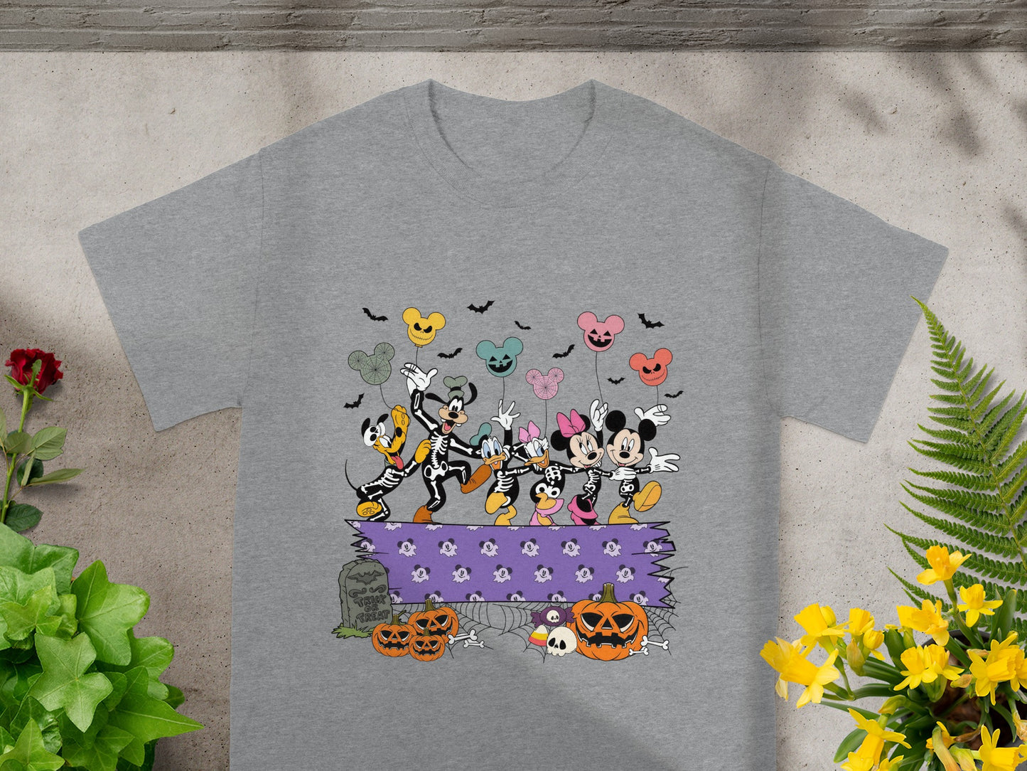Mickey and friends in skeleton costumes with Halloween pumpkins and balloons.