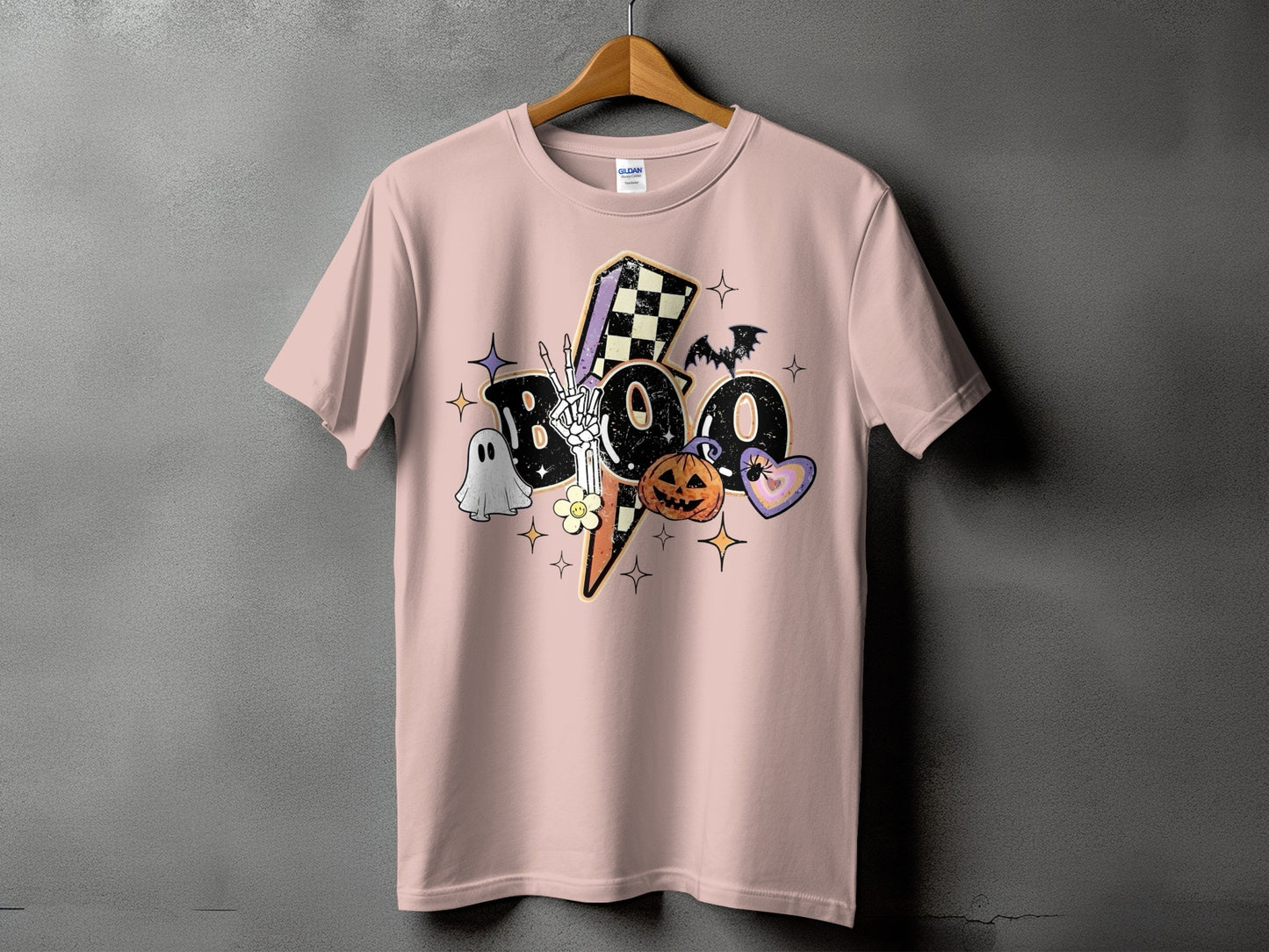 Pink t-shirt with "BOO" graphic featuring Halloween icons.