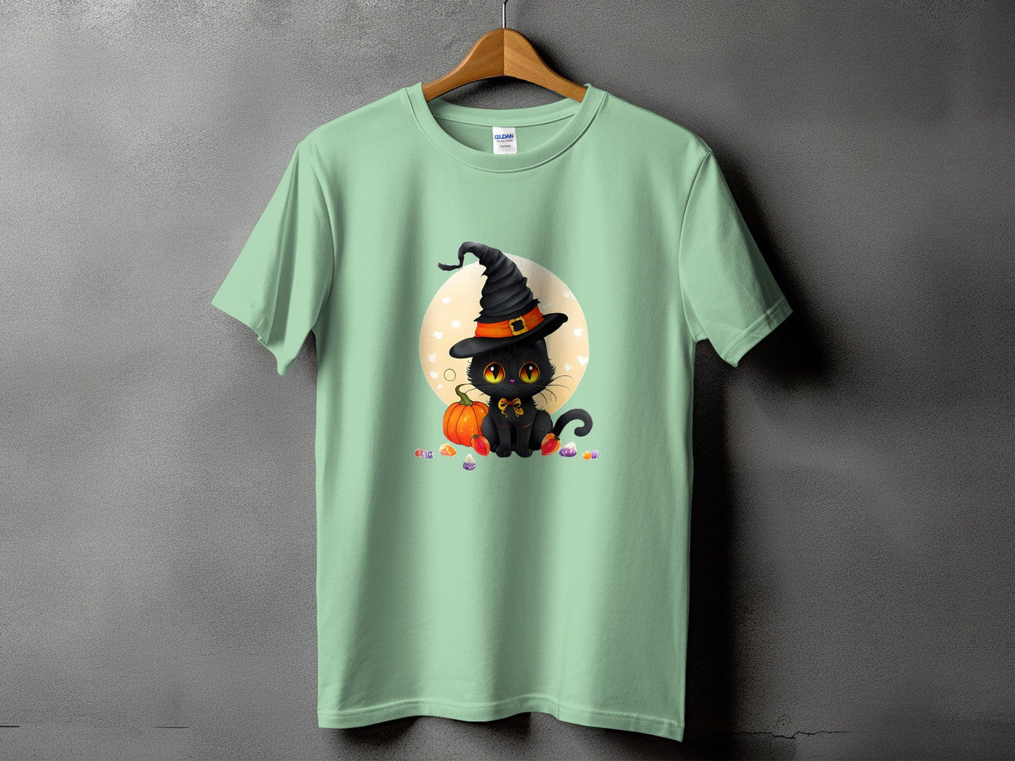 Light green t-shirt with black cat in witch hat and pumpkin graphic.