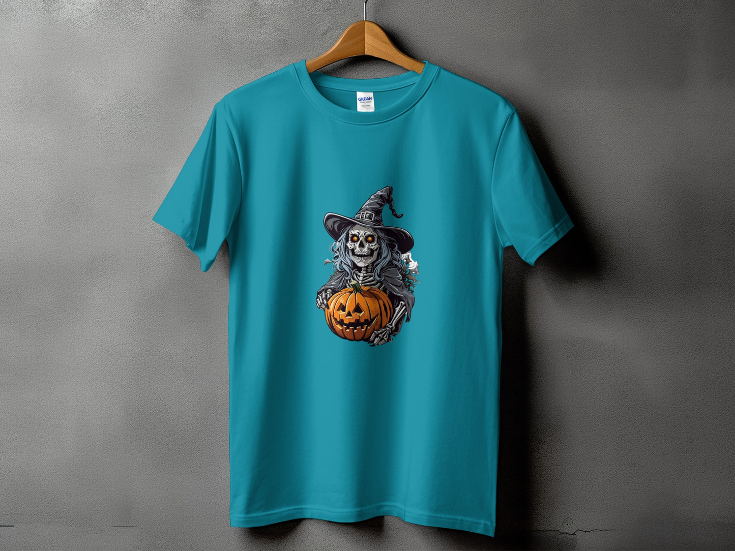 Teal t-shirt with skeleton wearing witch hat holding a pumpkin graphic.