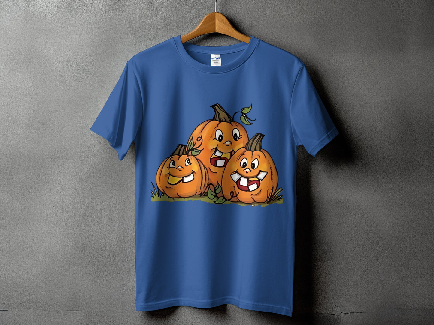 Blue t-shirt with a cartoon illustration of three smiling pumpkins.