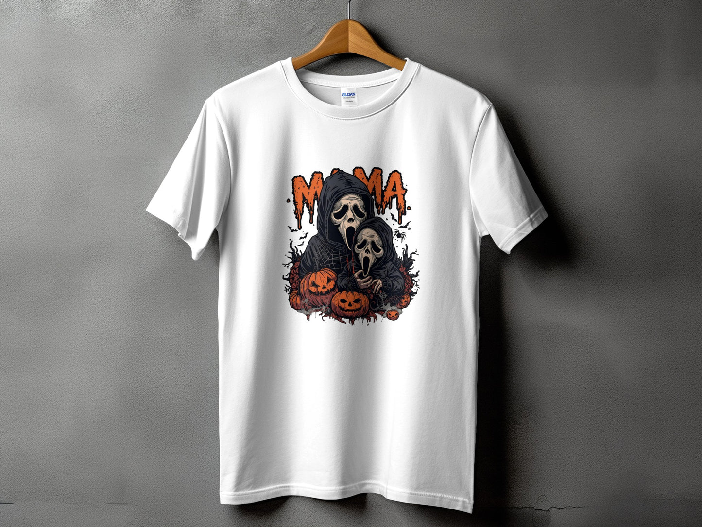 White t-shirt with "MAMA" text and spooky ghost and pumpkin Halloween graphic.