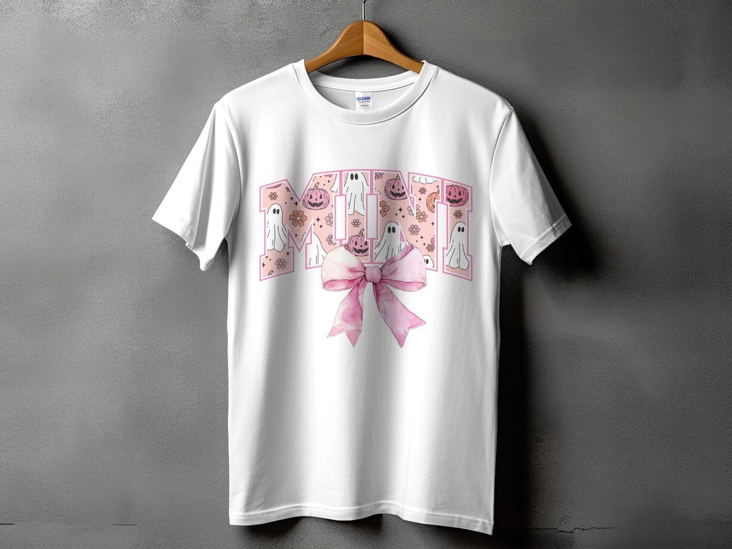 White t-shirt with "MOM" text and Halloween ghosts, pumpkins, and pink bow.