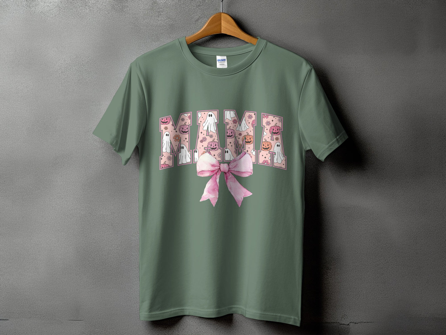 Green t-shirt with "Mama" text in a pattern of ghosts, pumpkins, and flowers.