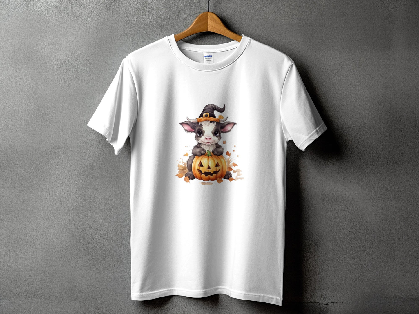 White t-shirt with a Halloween cow wearing a witch hat and sitting on a pumpkin.