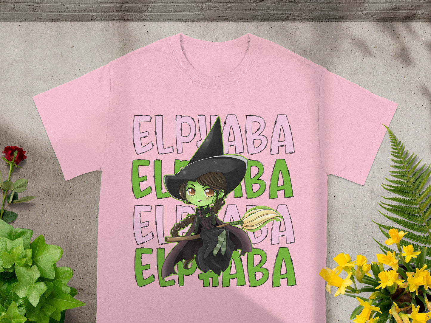 Pink t-shirt with "Elphaba" text and a witch illustration holding a broom.