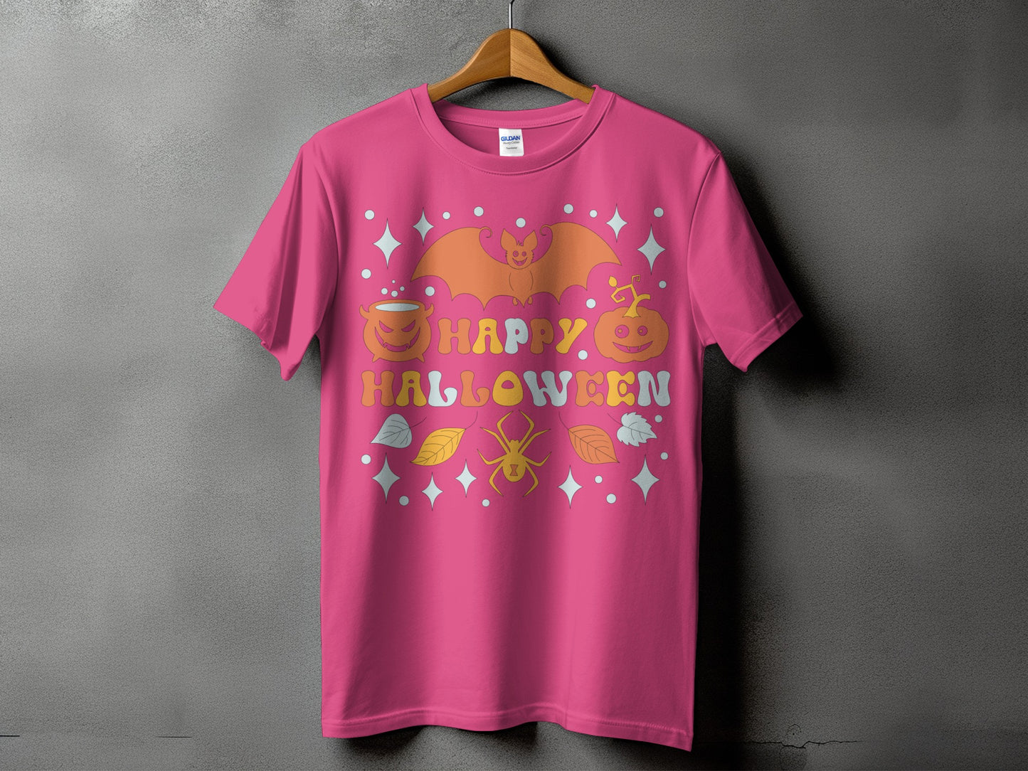 Pink t-shirt with "Happy Halloween" text and retro-style bat, pumpkin, and spider graphics.