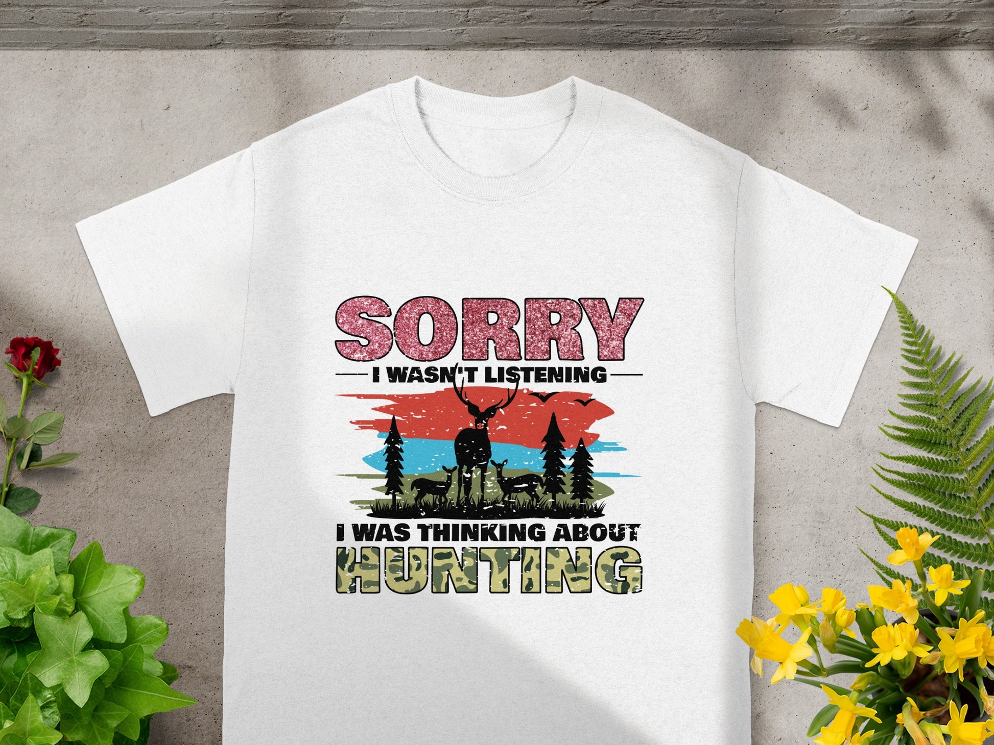 White t-shirt graphic with text "Sorry I wasn't listening I was thinking about Hunting" and deer graphic.