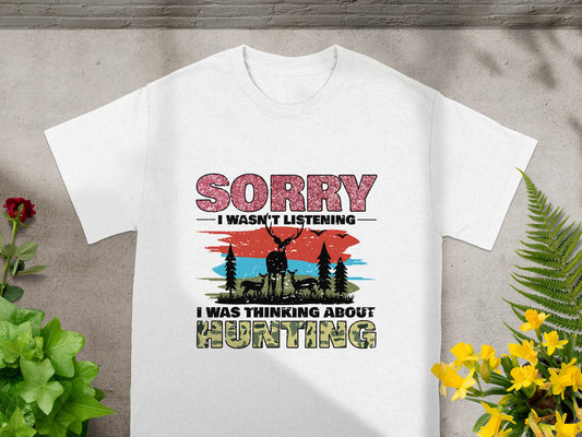 White t-shirt graphic with text "Sorry I wasn't listening I was thinking about Hunting" and deer graphic.