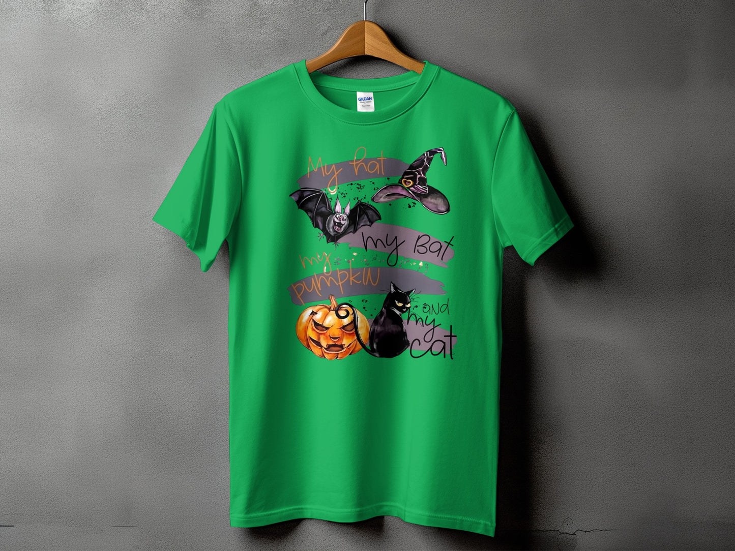 Green t-shirt with Halloween graphic: hat, bat, pumpkin, and cat.