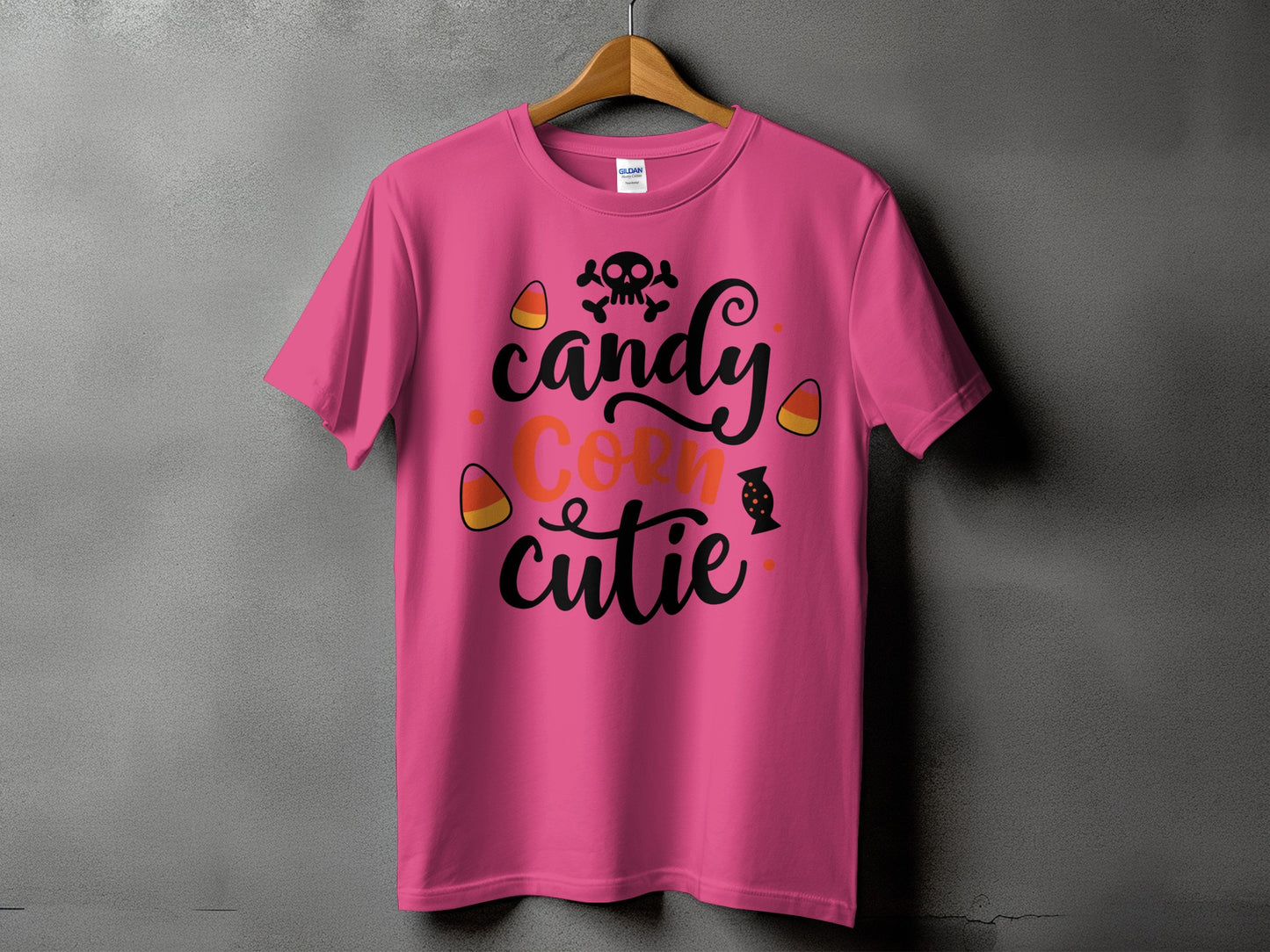 Pink t-shirt with "Candy Corn Cutie" Halloween text and skull graphic.