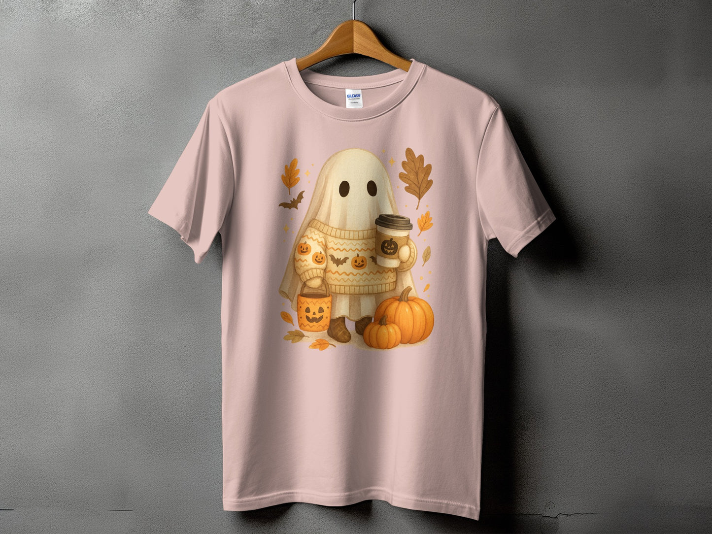 Ghost with pumpkins and coffee, wearing a sweater, on a pink t-shirt.