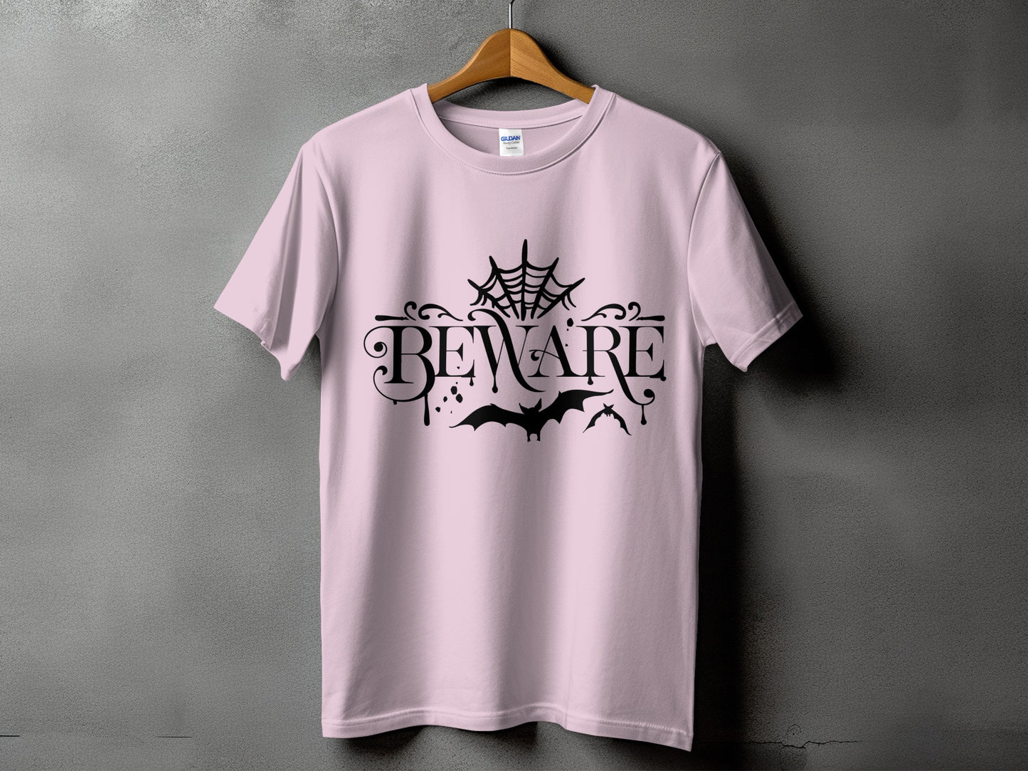 Pink t-shirt with black "BEWARE" text, cobweb, and bats design.