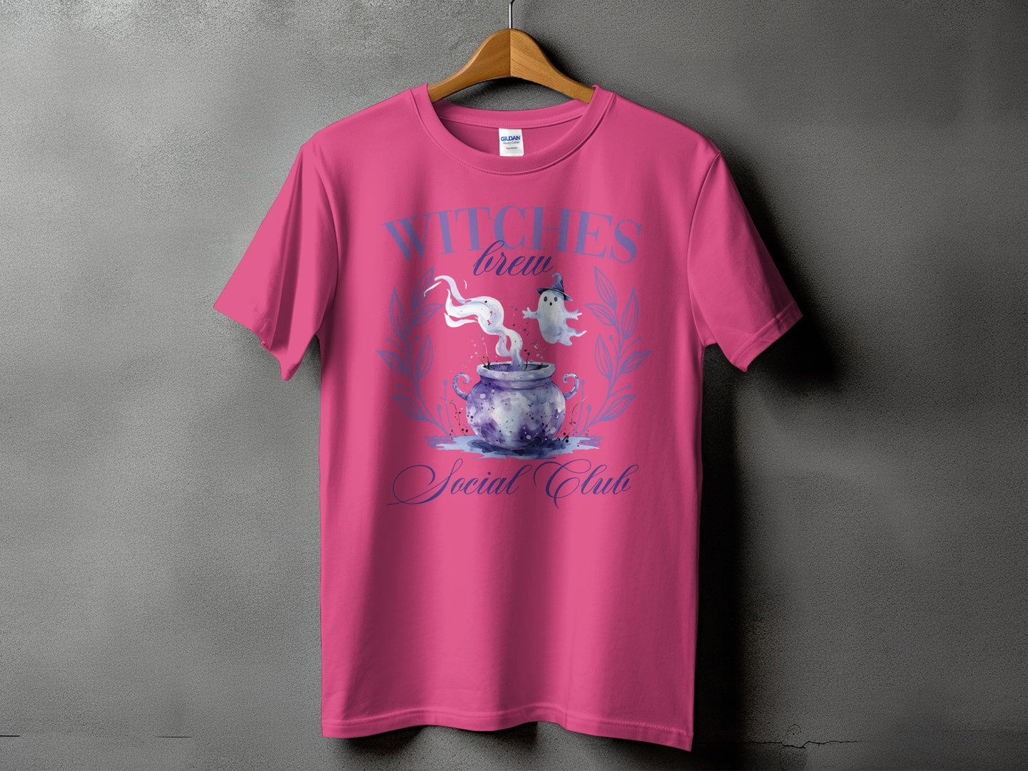 Pink t-shirt with "Witches Brew Social Club" text and cauldron graphic.