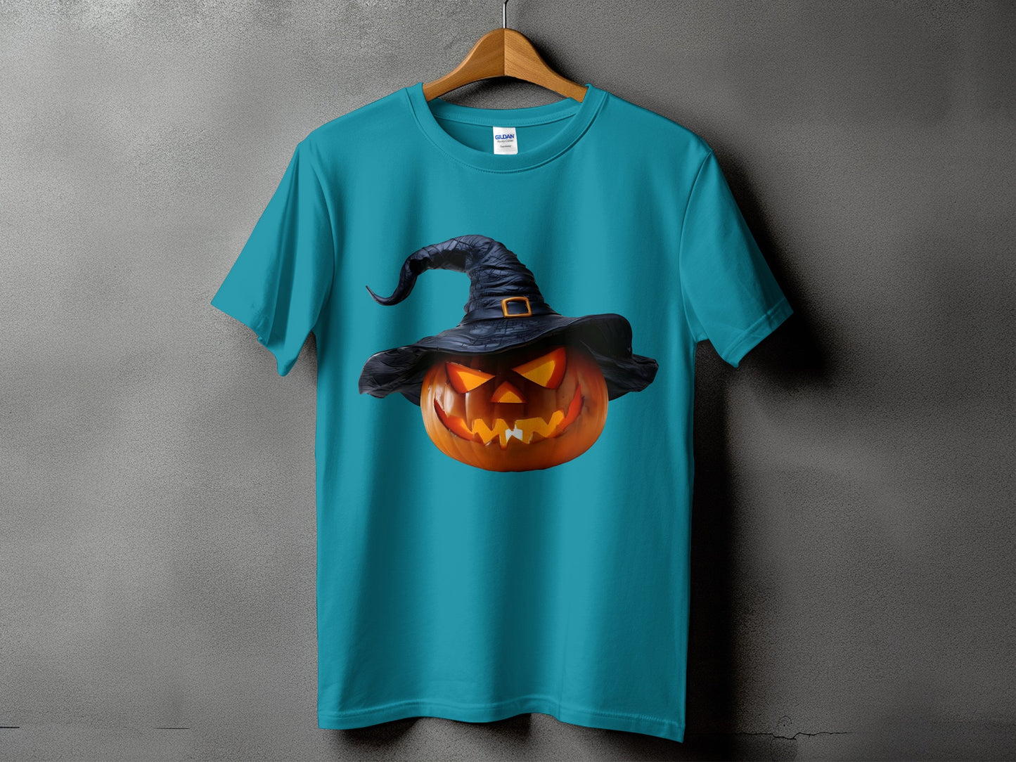 Teal t-shirt with carved pumpkin wearing a witch hat graphic.