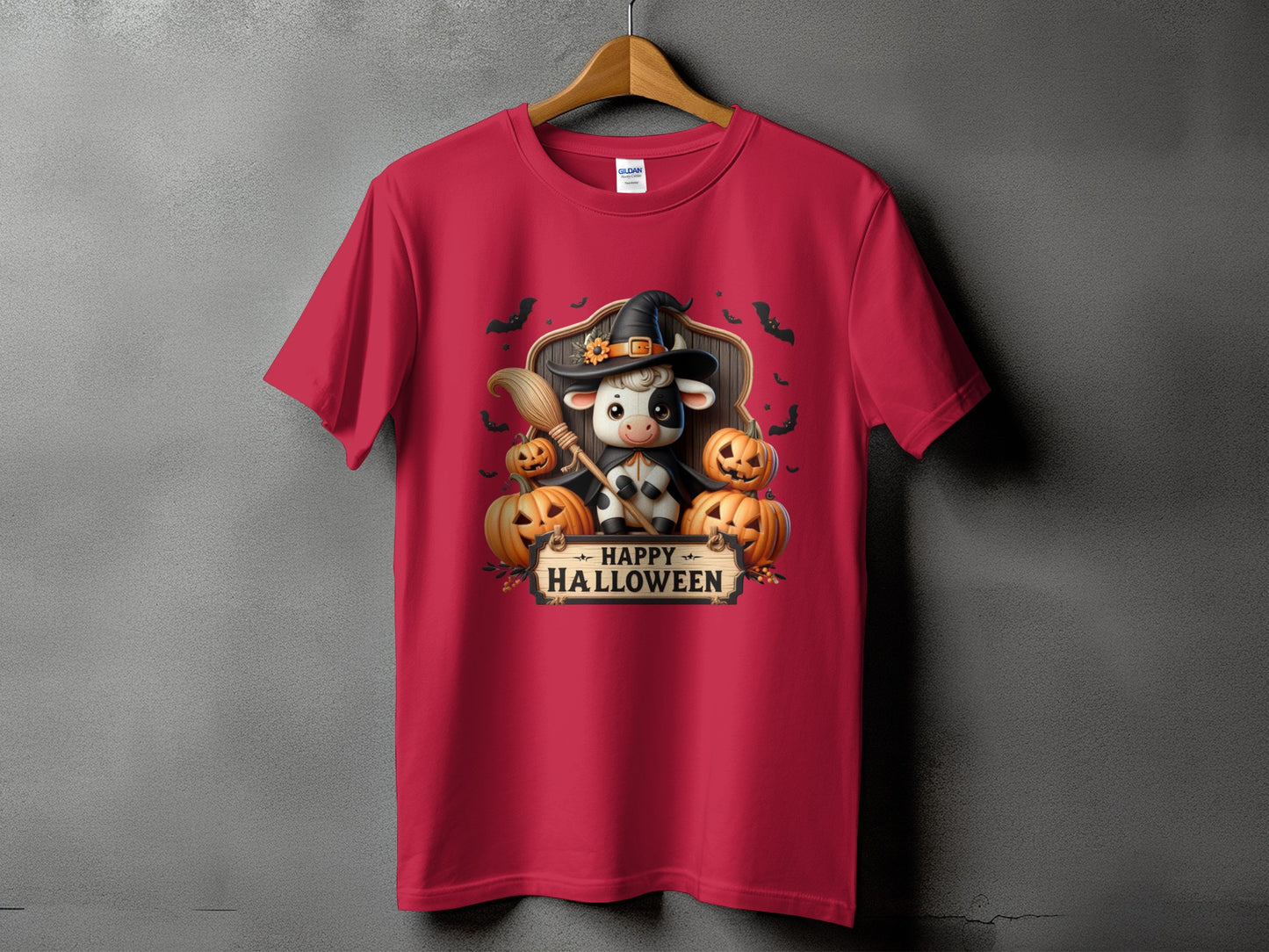 Red t-shirt with a cow in a witch hat holding a broom, pumpkins, and "Happy Halloween" text.