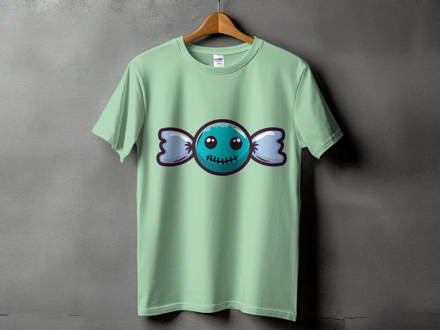 Mint green t-shirt featuring a cartoon blue candy with a stitched mouth.