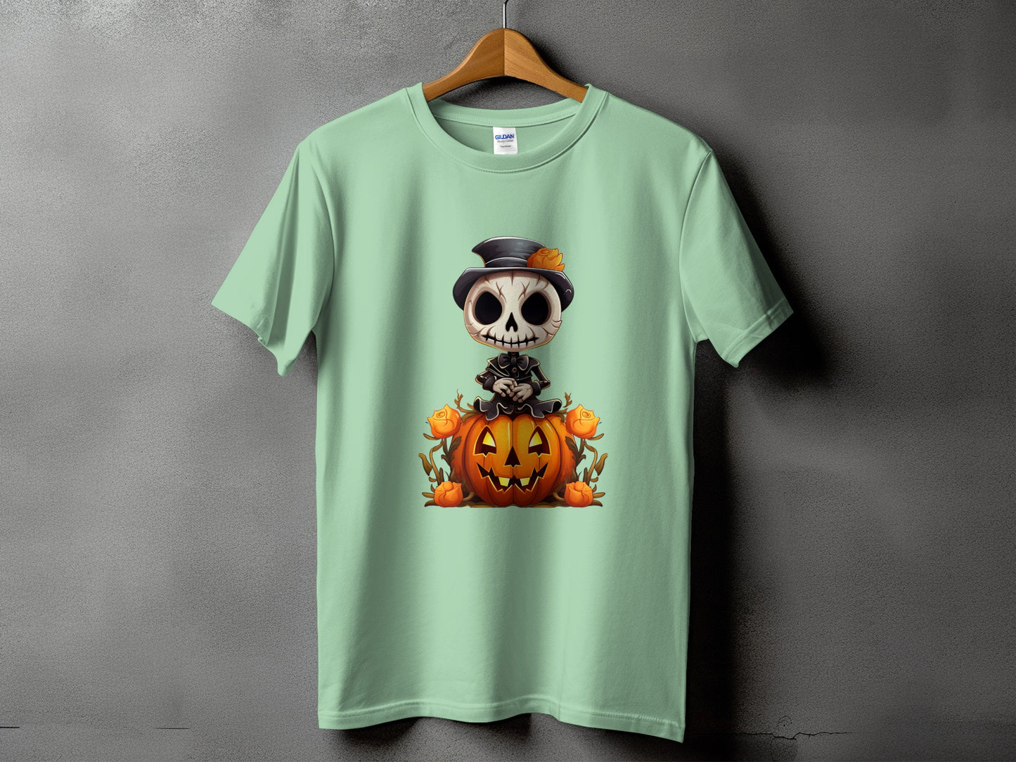 Light green t-shirt with a cartoon skeleton sitting on a jack-o'-lantern.