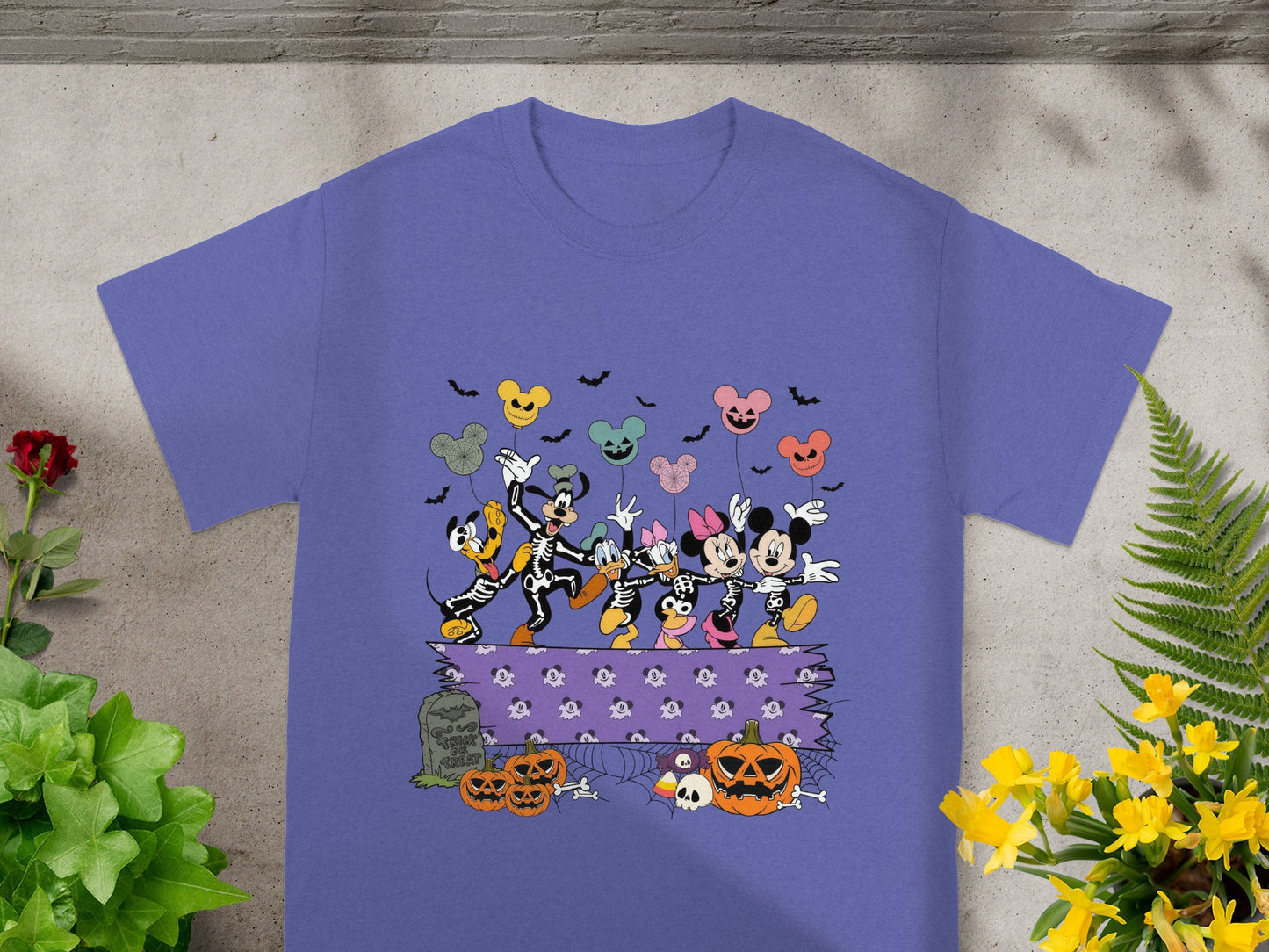 Mickey Mouse Halloween skeleton characters dancing with pumpkins and bats.