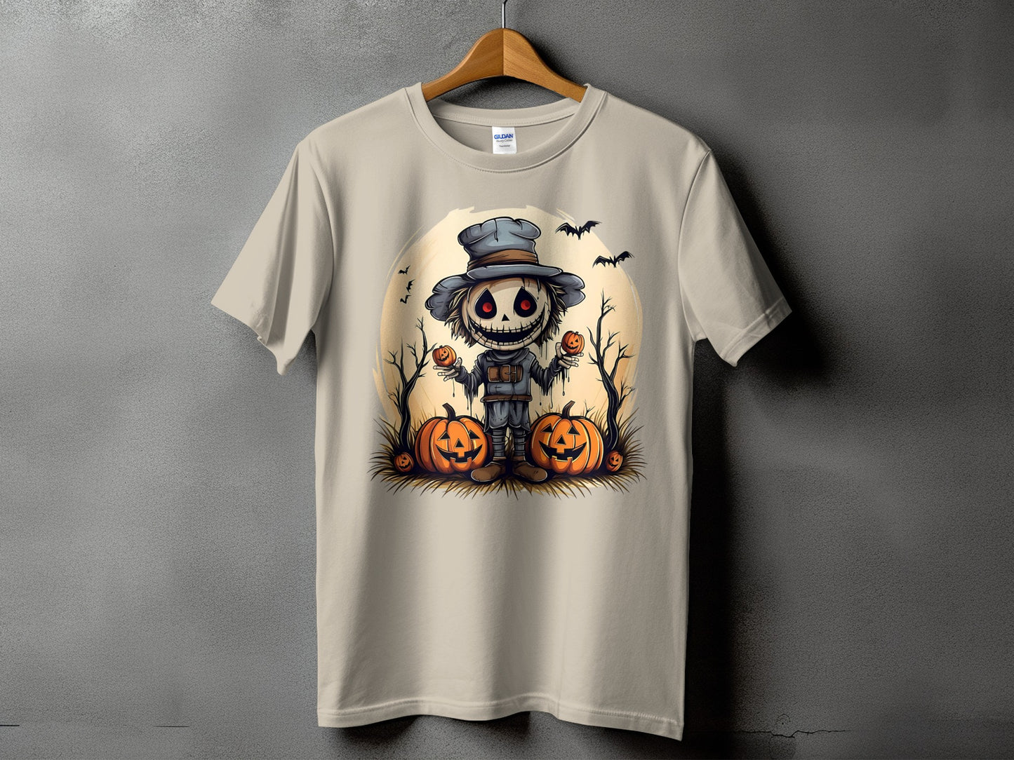 Light tan t-shirt with a Halloween scarecrow, pumpkins, and bats graphic.