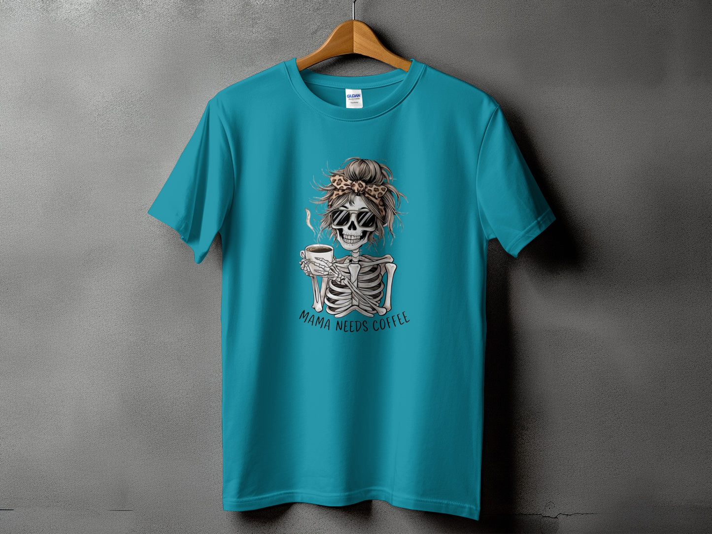 Teal t-shirt with skeleton wearing sunglasses and leopard print bandana holding coffee, text "Mama Needs Coffee."