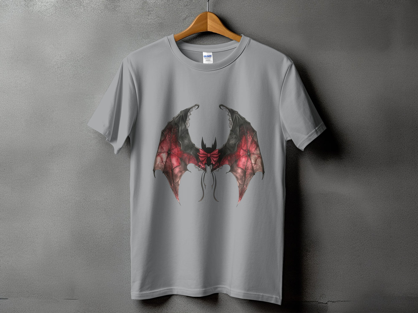 Grey t-shirt with a red and black bat wings graphic with a bow.