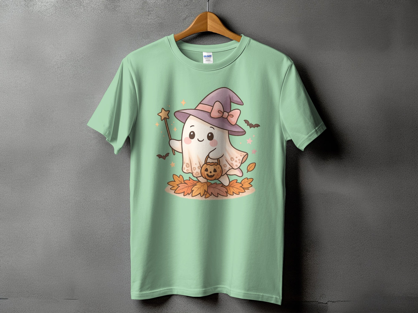 Mint green t-shirt with a Halloween ghost wearing a witch hat and holding a pumpkin.