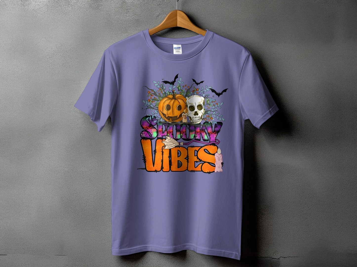 Purple t-shirt with Halloween design of pumpkin, skull, bats, broom, and text "Spooky Vibes".