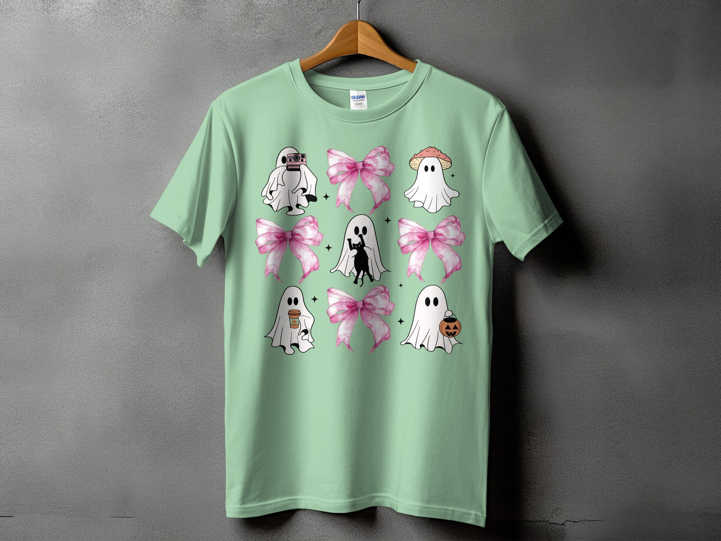 Mint t-shirt with a pattern of cute ghosts, pink bows, and Halloween icons.