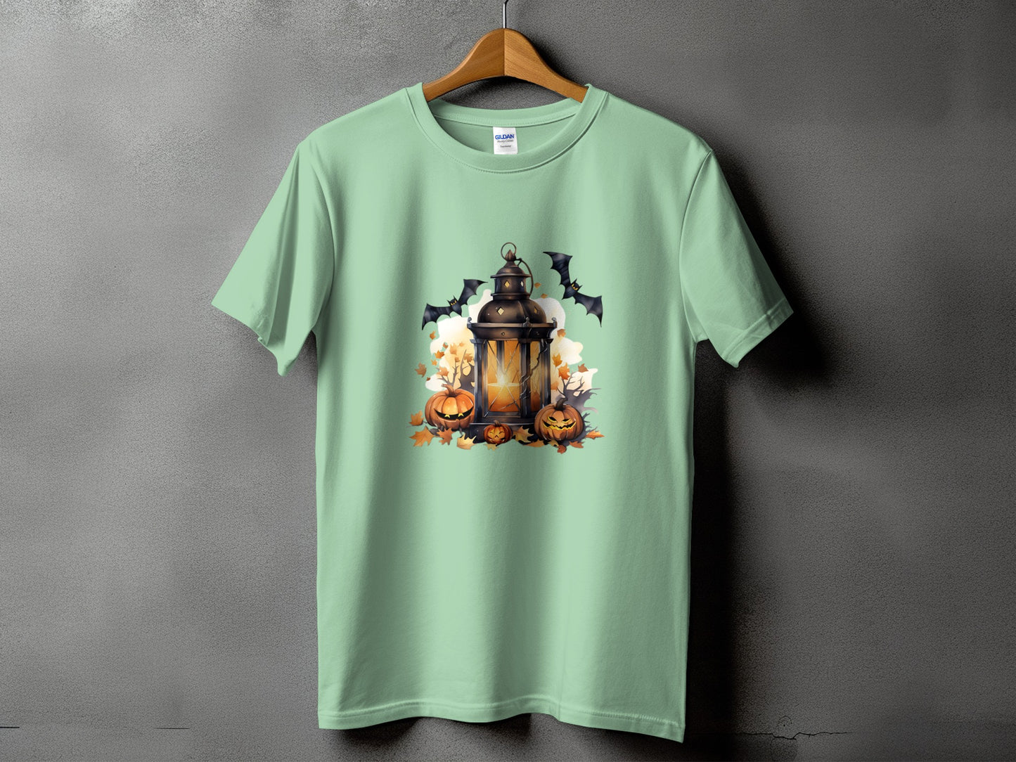 Light mint green t-shirt with a Halloween graphic of a lantern, pumpkins, and bats.