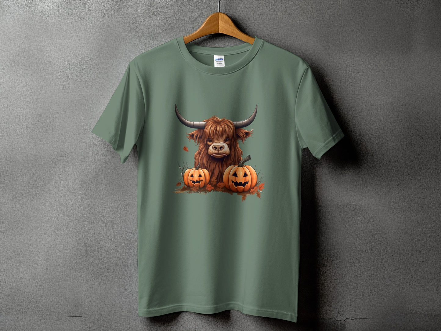 Green t-shirt with a Halloween graphic of a Highland cow and pumpkins.
