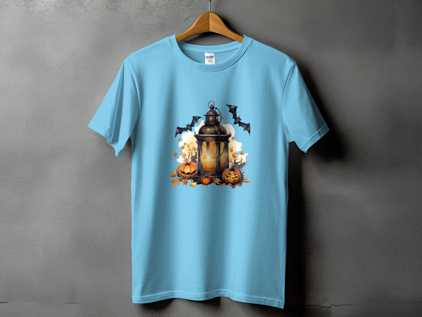 Light blue t-shirt with Halloween graphic of lantern, pumpkins, and bats.