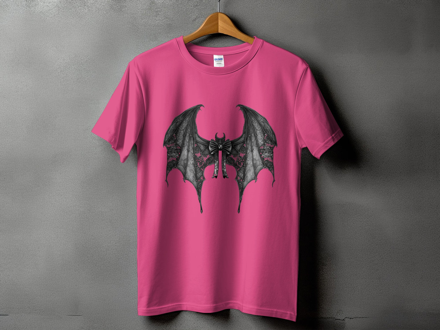 Pink t-shirt with detailed black bat wings and bow graphic design.