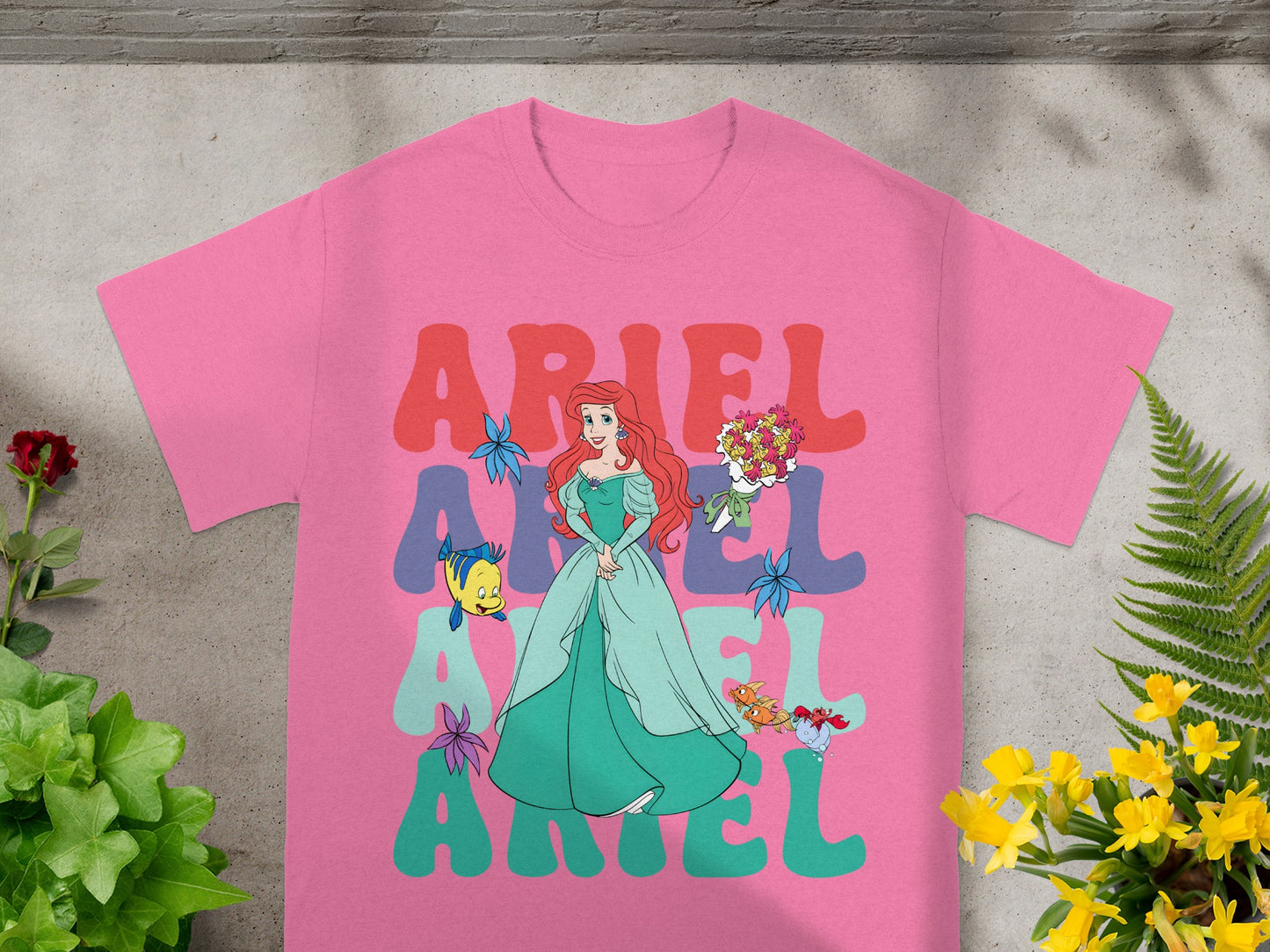 Pink t-shirt with Ariel and "ARIEL" text in colorful letters.