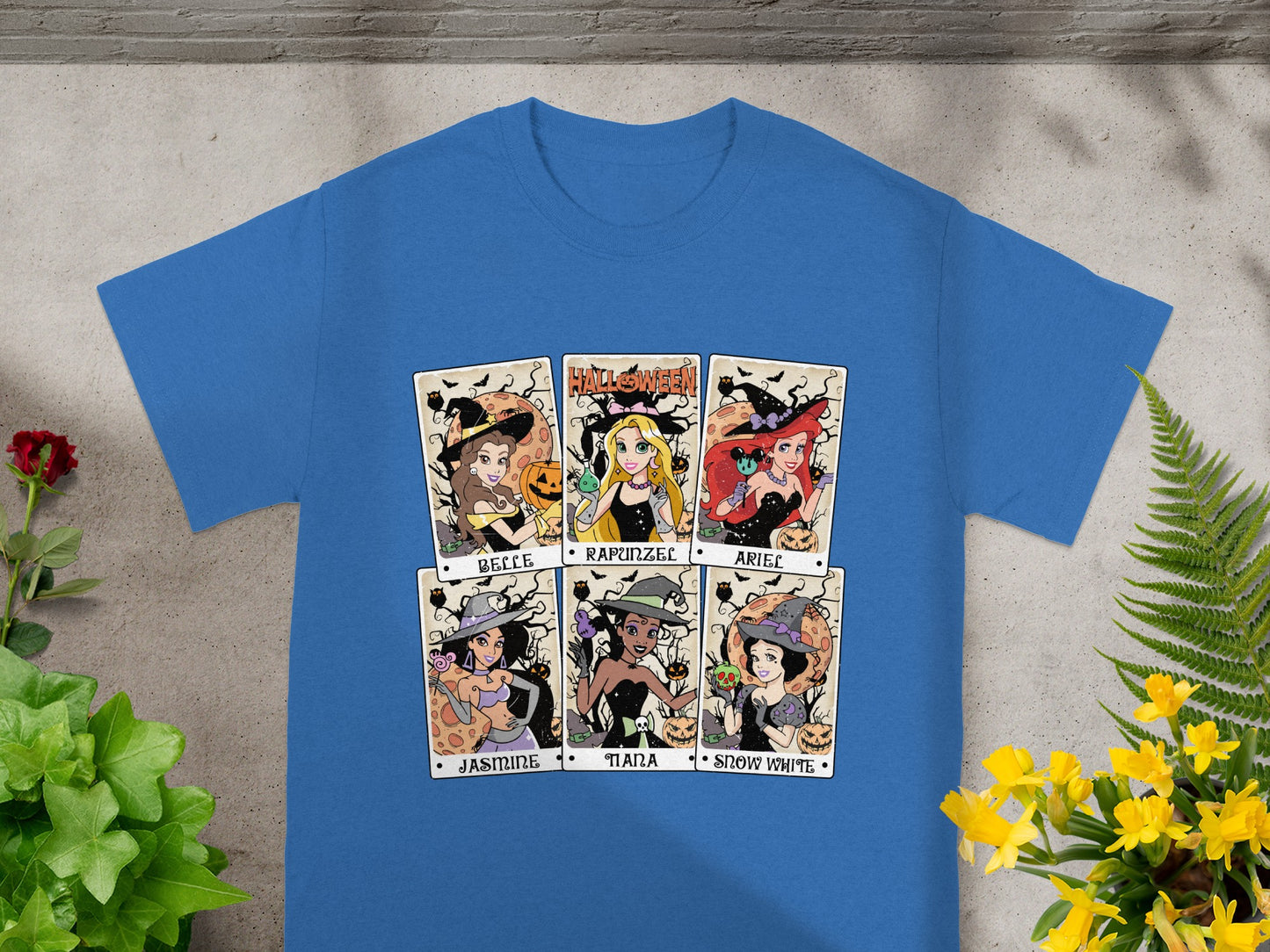 Blue t-shirt with six Halloween-themed princess illustrations labeled Belle, Rapunzel, Ariel, Jasmine, Tiana, and Snow White.