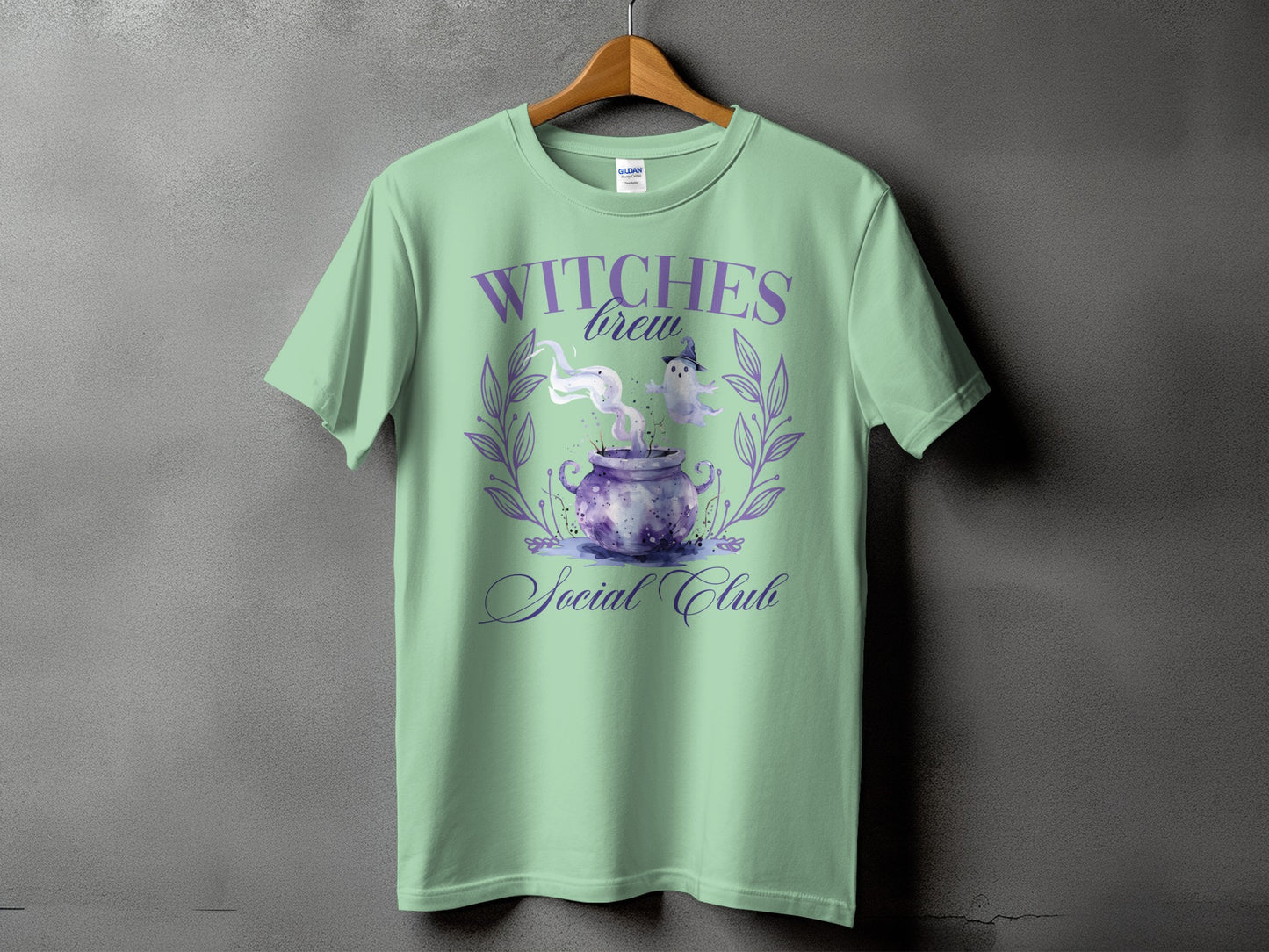Mint green t-shirt with "Witches Brew Social Club" text and cauldron graphic.