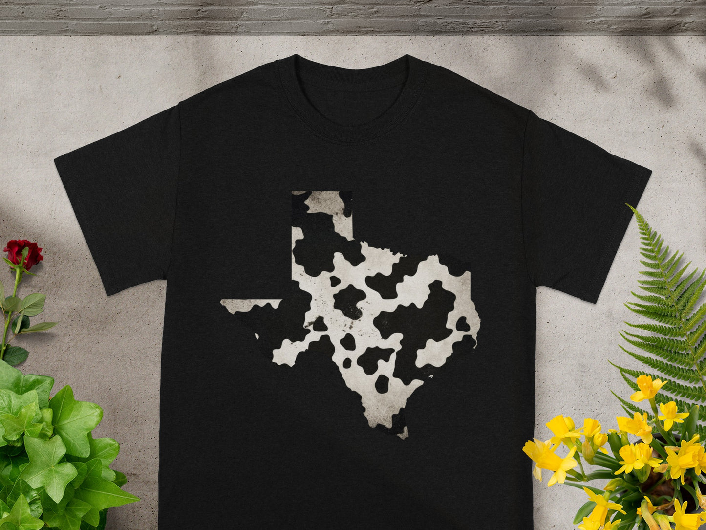 Black t-shirt with a cow print Texas outline graphic.