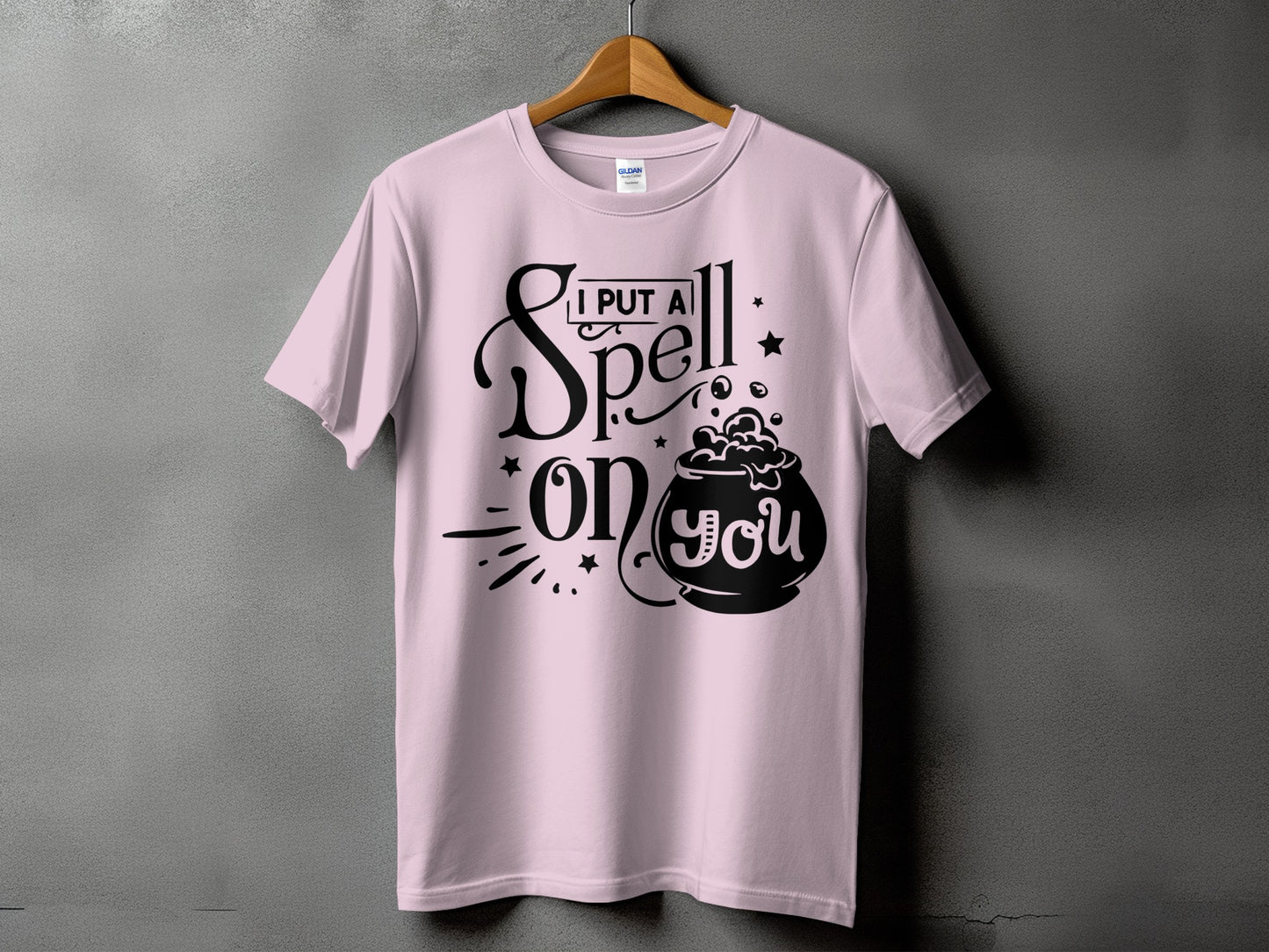 Pink t-shirt with black graphic saying "I Put A Spell On You" and a cauldron.